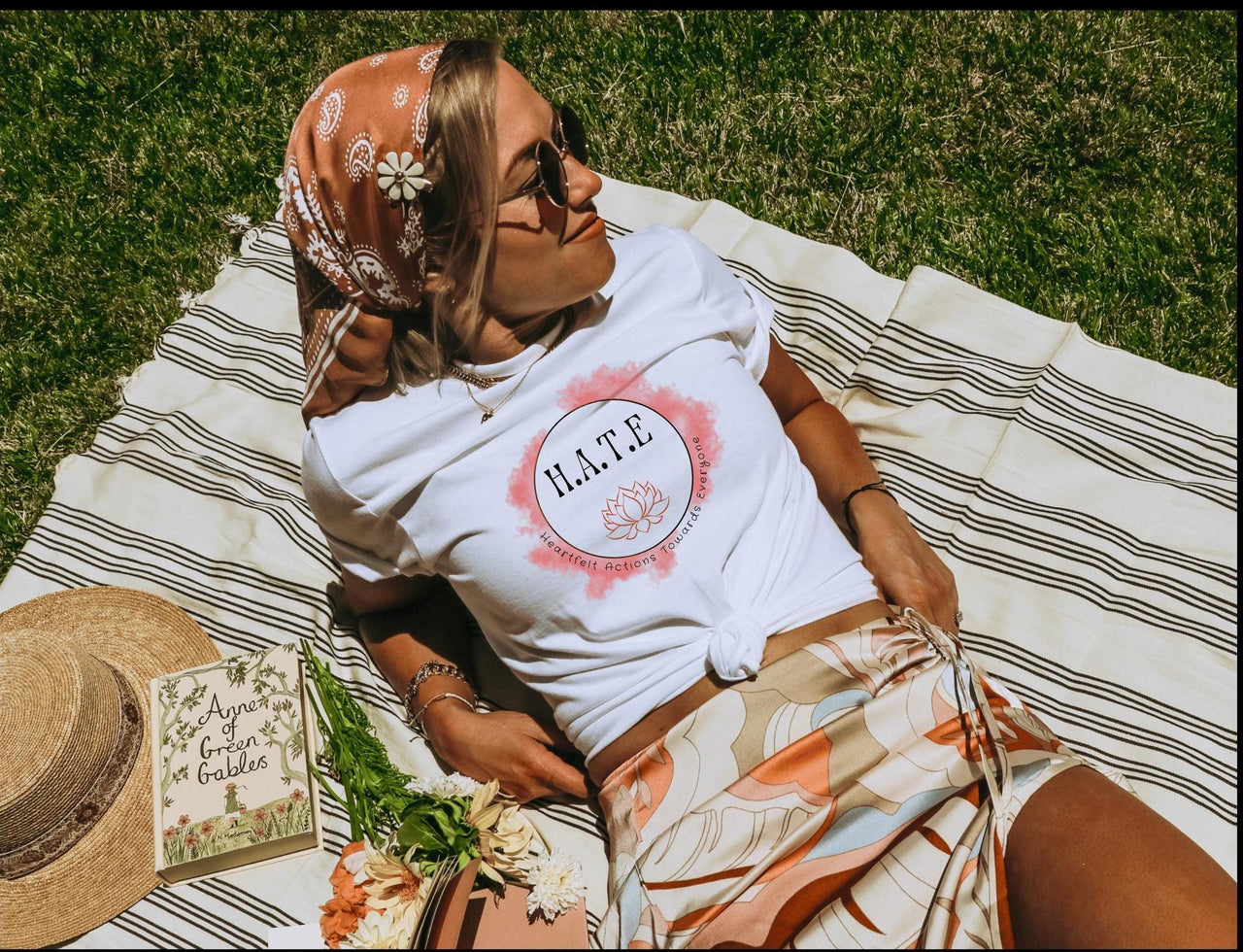 a woman laying on top of a blanket next to a hat