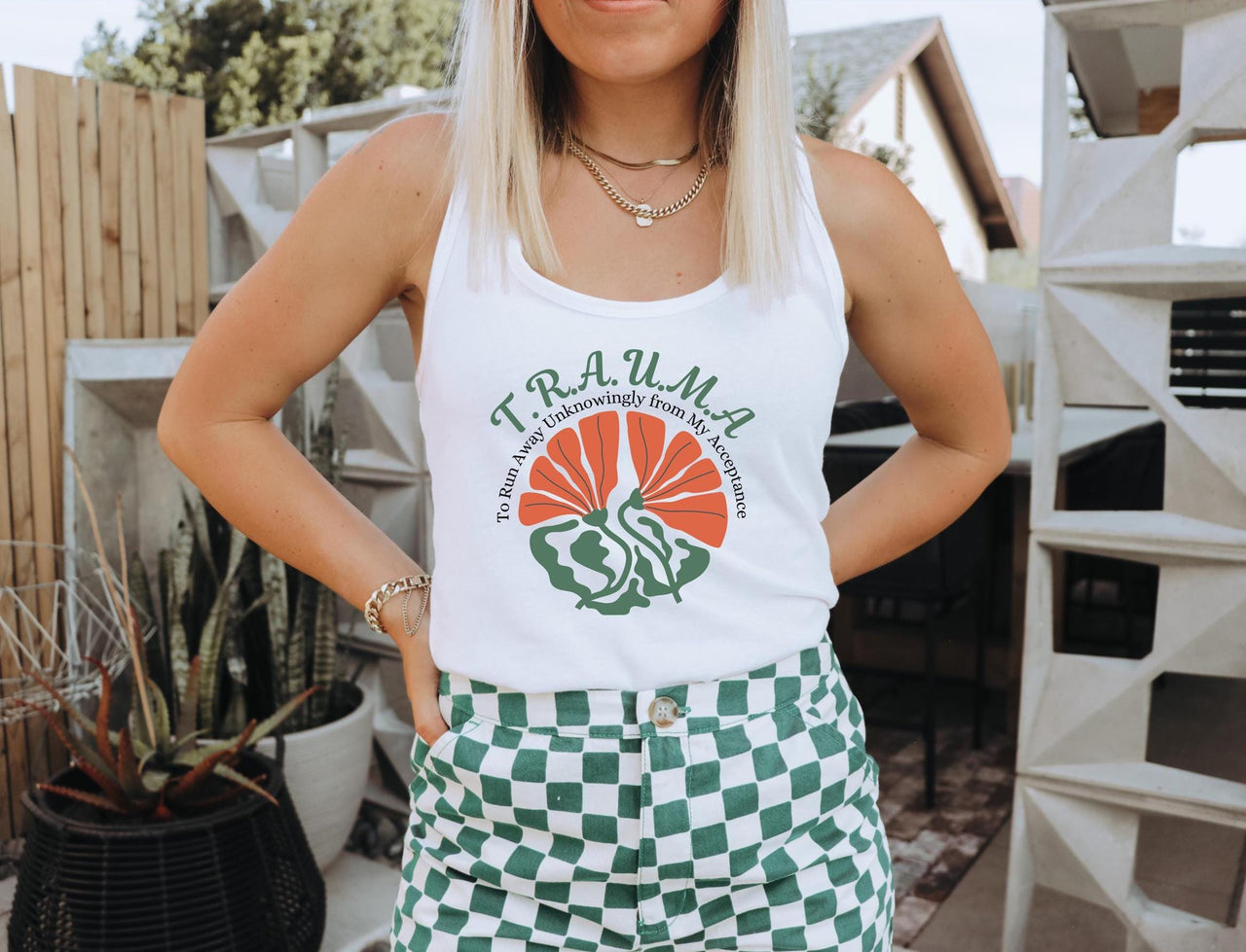 a woman wearing a white tank top and green checkered shorts