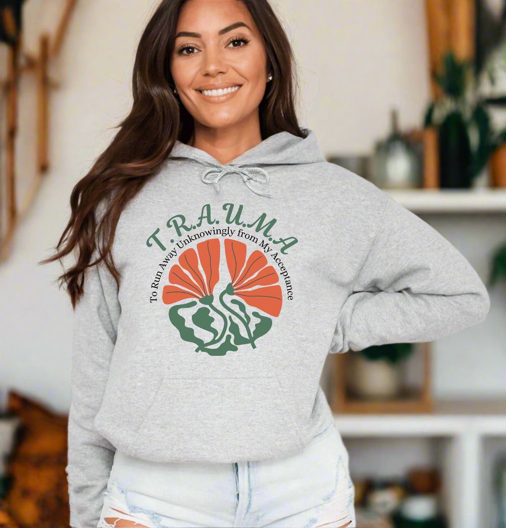 a woman wearing a gray sweatshirt with a green and orange graphic on it