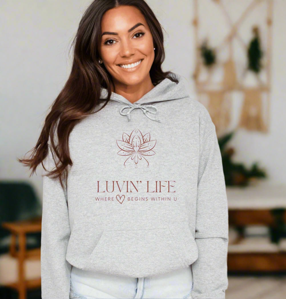 a woman wearing a grey hoodie with the luvin'life logo on it