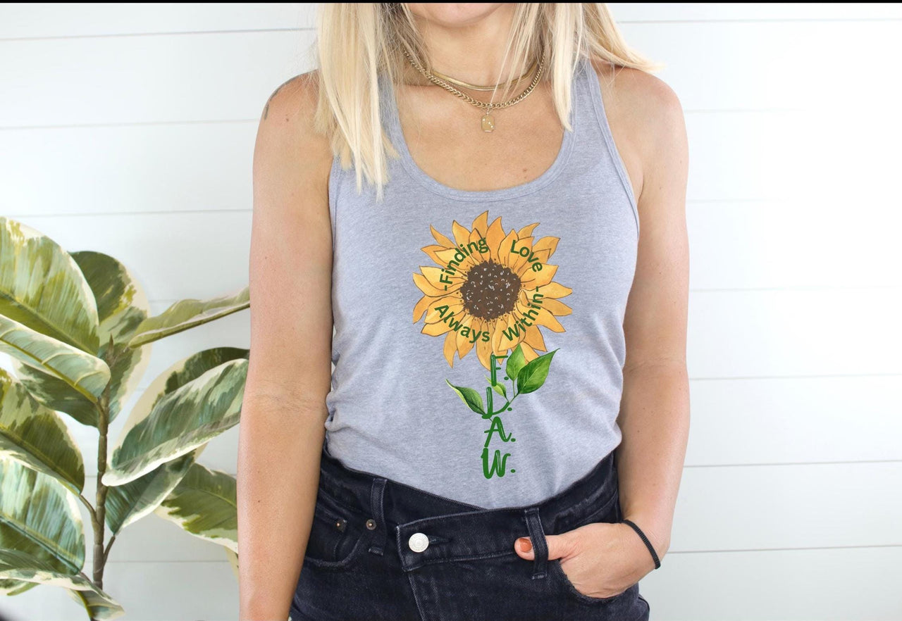a woman wearing a tank top with a sunflower on it