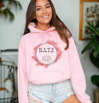 Thumbnail for a woman wearing a pink hoodie that says h a t e