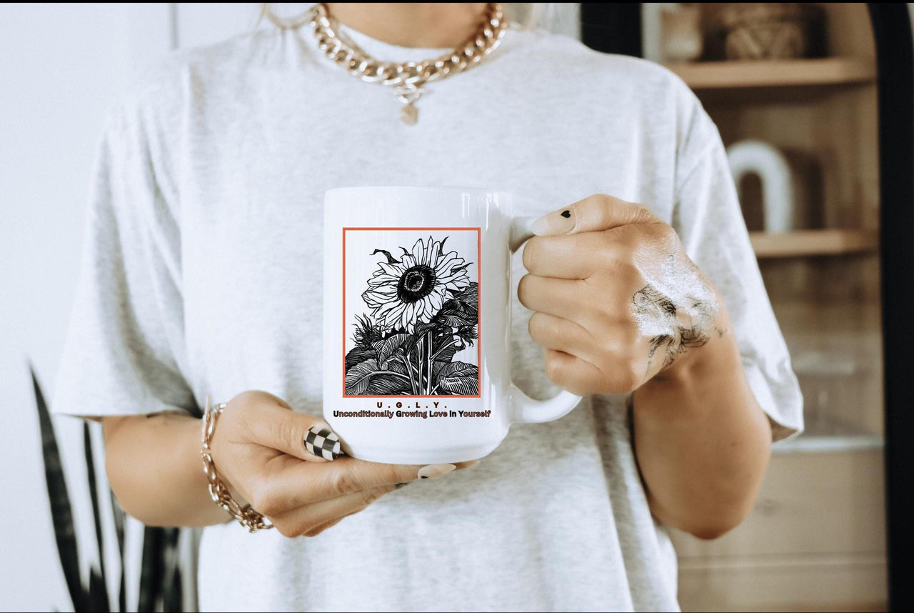 a woman holding a coffee mug with a picture of a sunflower on it