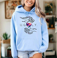 Thumbnail for a woman wearing a light blue hoodie with the words ugly on it