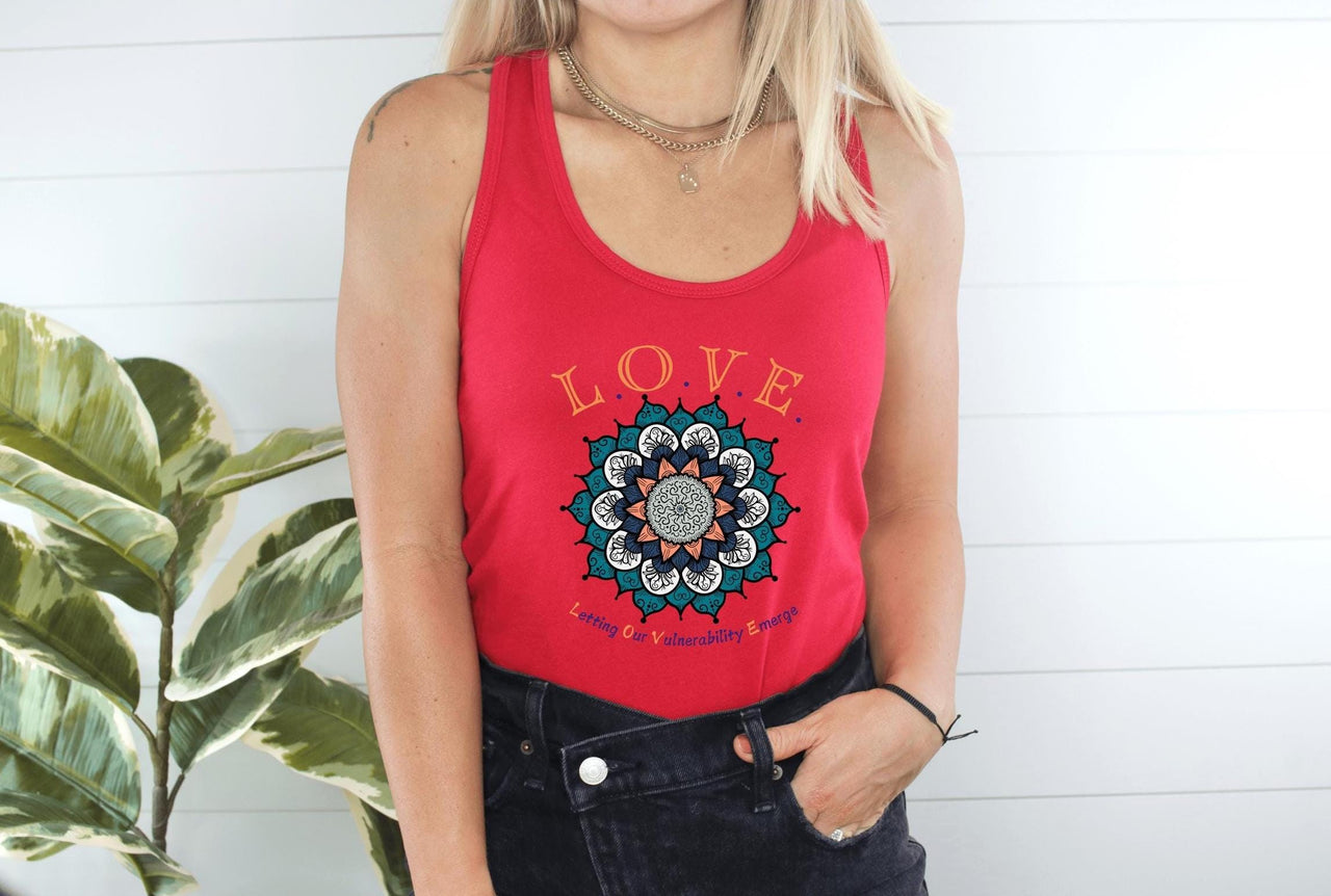 a woman standing next to a plant wearing a red tank top