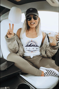 Thumbnail for a woman sitting in the back of a car holding up a peace sign