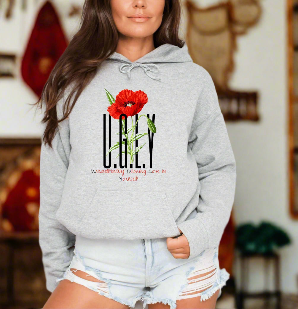 a woman wearing a grey hoodie with a red flower on it