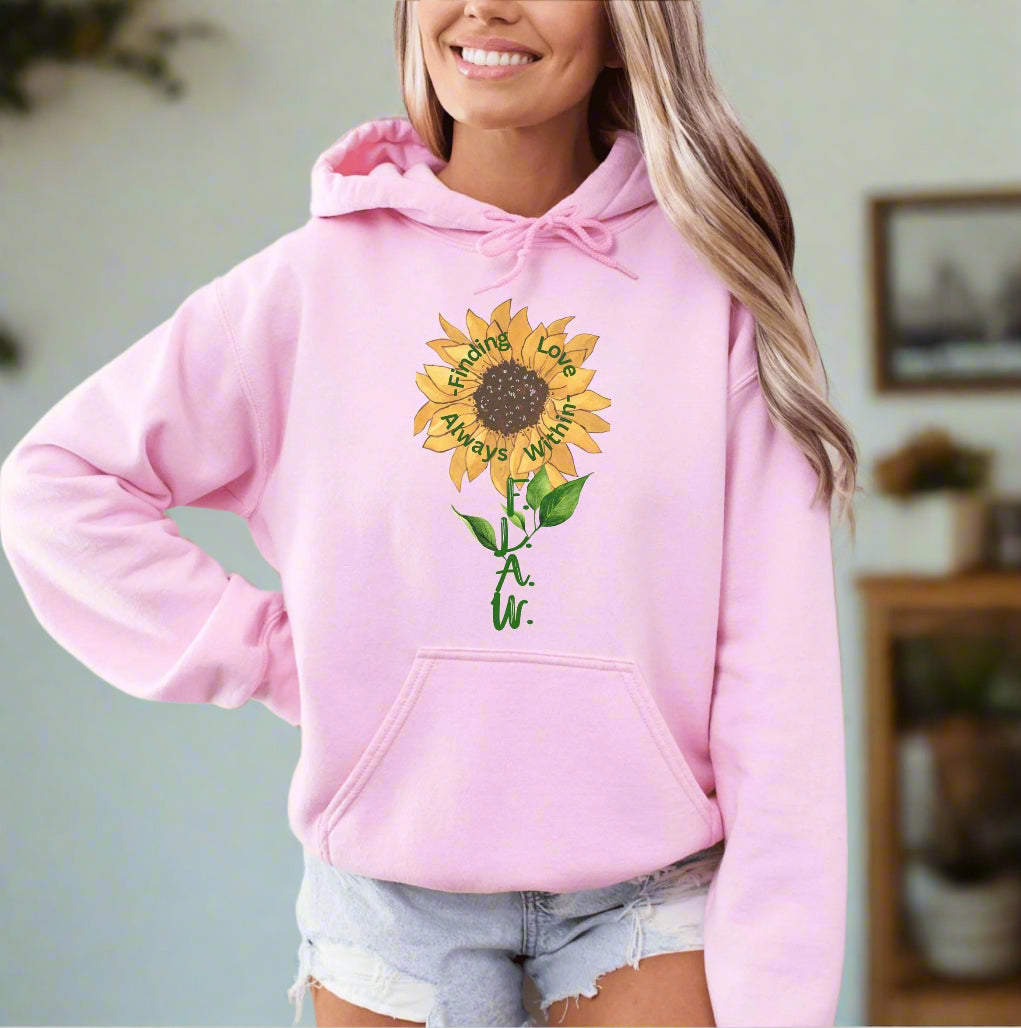 a woman wearing a pink hoodie with a sunflower on it