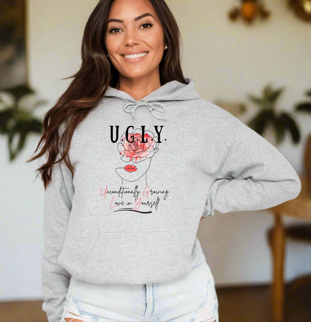 a woman wearing a grey hoodie with the words ugly on it