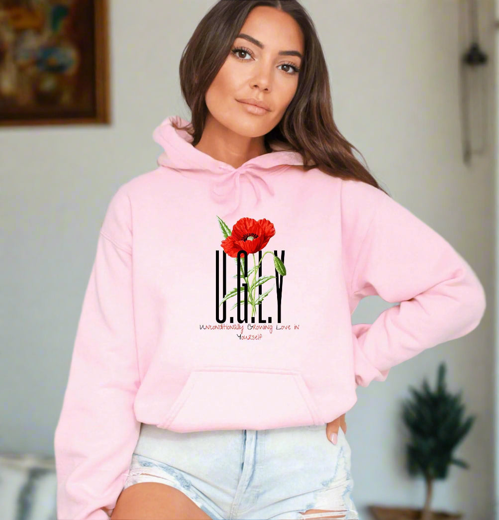 a woman wearing a pink hoodie with a flower on it
