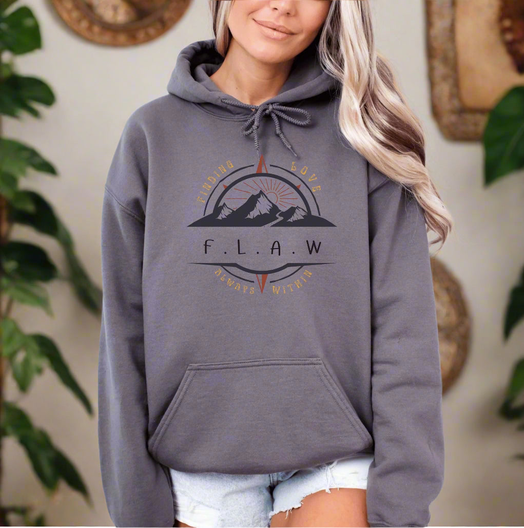 a woman wearing a gray hoodie with a mountain scene on it