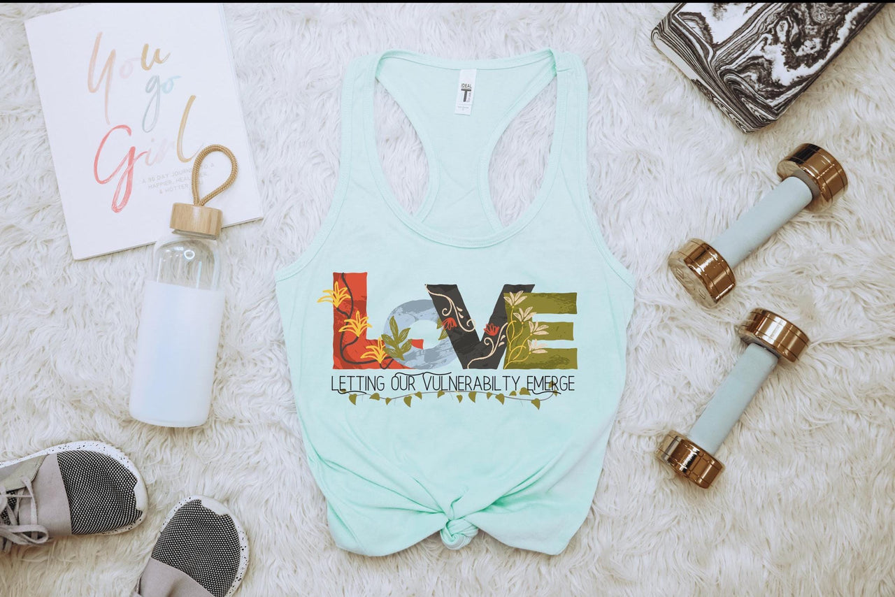 a women's tank top and other items laid out on a bed