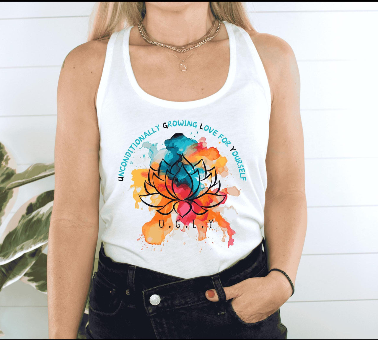 a woman wearing a white tank top with a colorful lotus on it