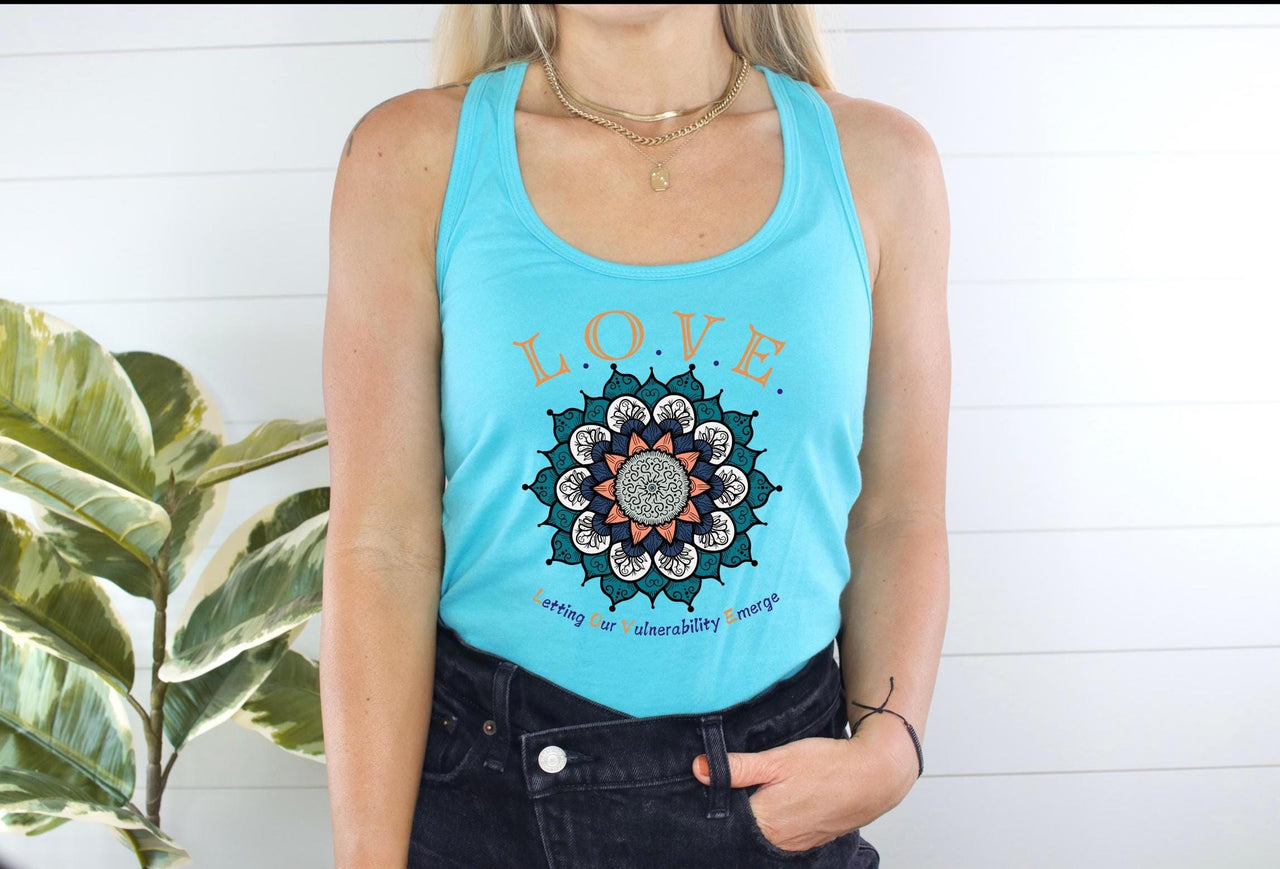 a woman standing next to a plant wearing a blue tank top