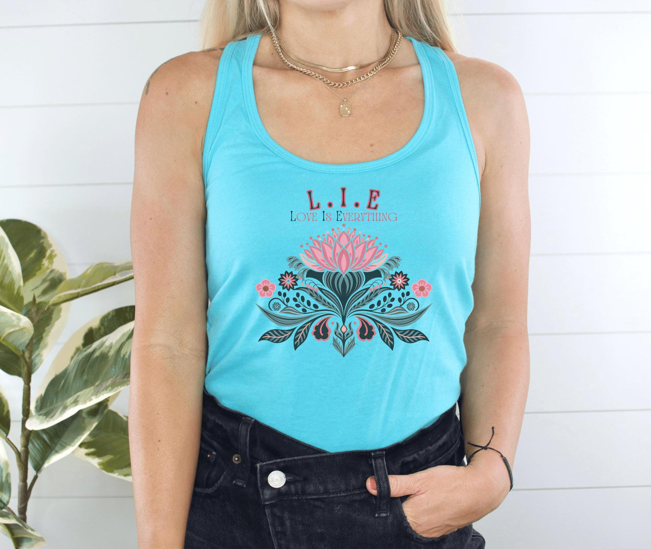 a woman wearing a blue tank top with a pink flower on it