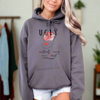 Thumbnail for a woman wearing a grey hoodie with the words ugly on it