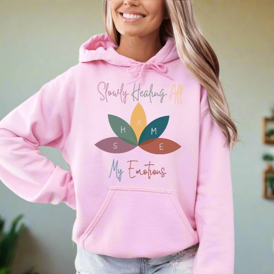 a woman wearing a pink hoodie with a flower on it