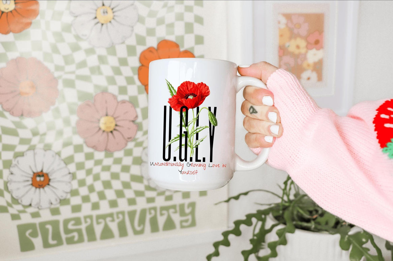 a person holding a coffee mug with a flower on it