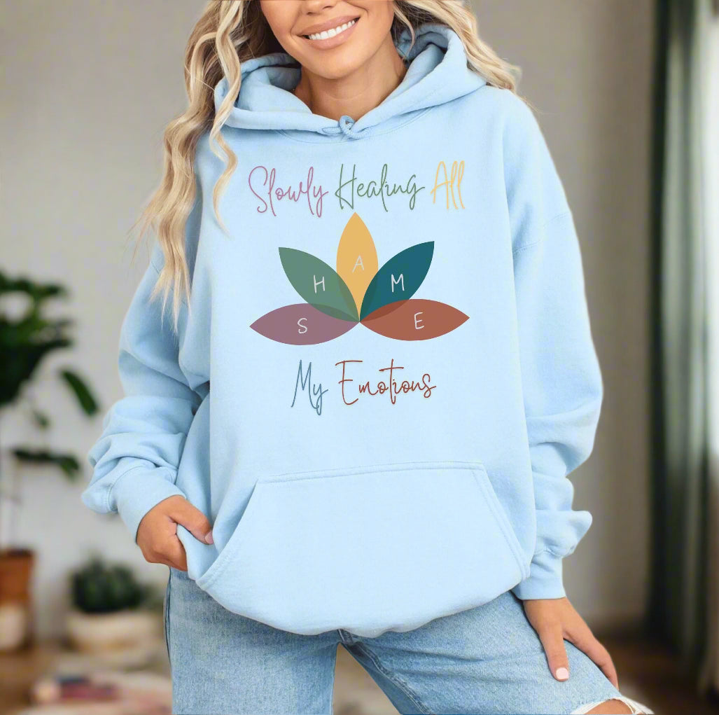 a woman wearing a light blue sweatshirt with leaves on it