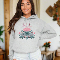 Thumbnail for a woman wearing a grey hoodie with a pink flower on it