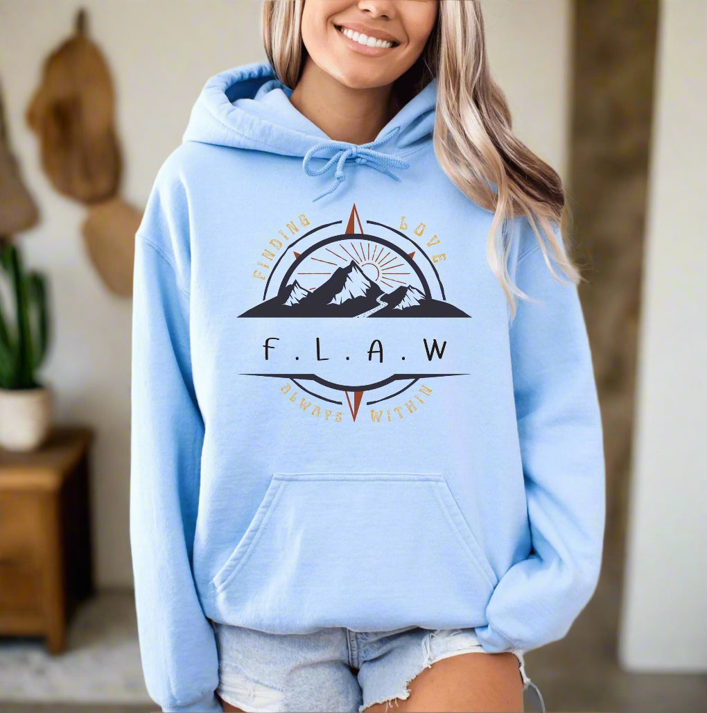 a woman wearing a light blue hoodie with a mountain scene on it