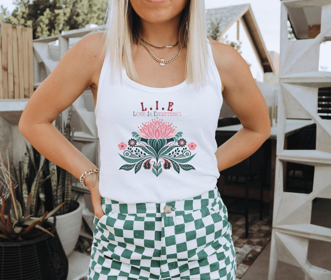 a woman wearing a white tank top and green checkered shorts