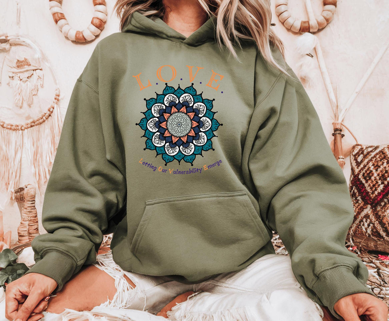 a woman wearing a green hoodie with a flower on it