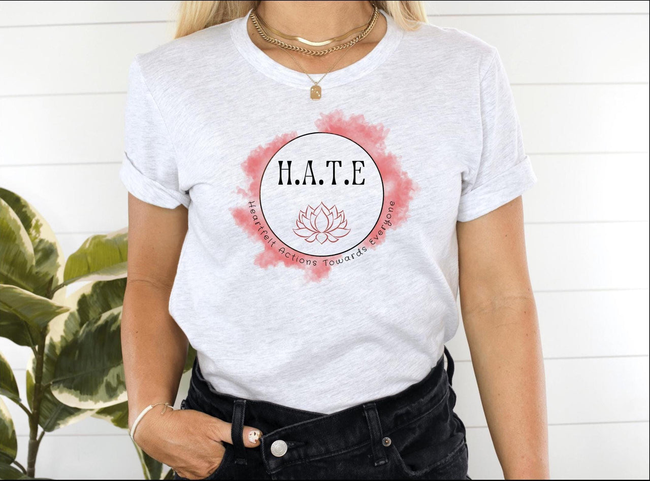 a woman wearing a white t - shirt with the word hate on it